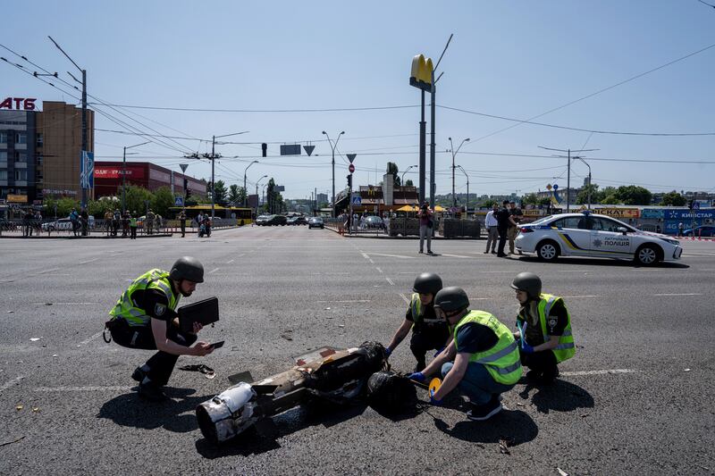 Ukrainian police officers inspecting a fragment of the rocket after a Russian rocket attack in Kyiv. Photograph: Evgeniy Maloletka/AP