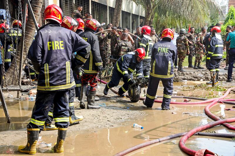 Bangladesh's fire service personnel clear the remains of an Air Force training jet that crashed into a school, during a search and rescue operation in Dhaka on Monday. Photograph: Abdul Goni/AFP