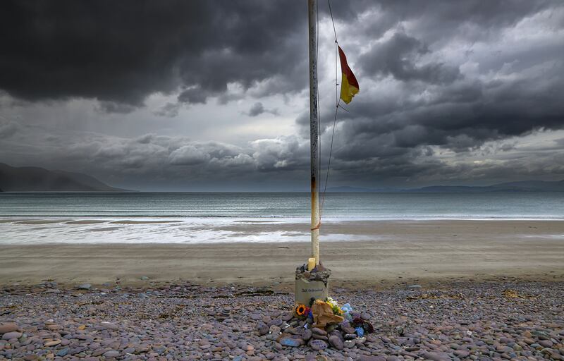 A lifeguard flag flies at half-mast over a makeshift memorial site of flowers and tributes for the late Jack de Bromhead, who died tragically, at Glenbeigh Races on Saturday. Photo: Valerie O'Sullivan