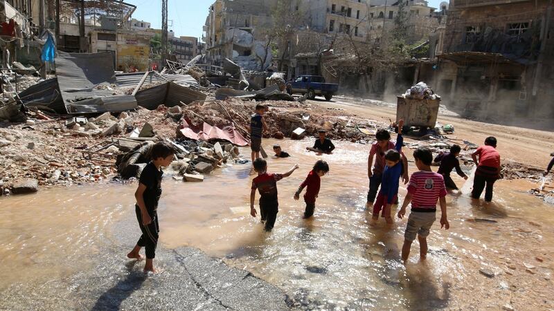 Children play with water from a burst water pipe at a site hit yesterday by an air strike in Aleppo’s rebel-controlled al-Mashad neighbourhood. Photograph: Reuters