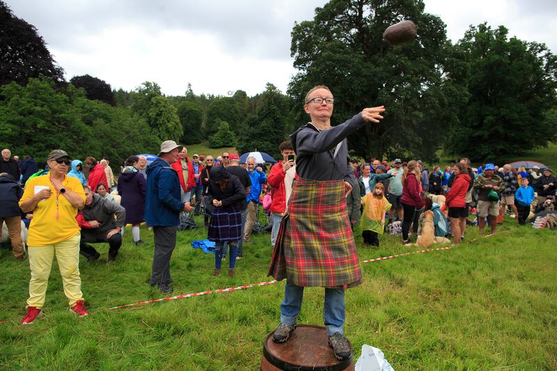 A dog owner takes part in a haggis hurling competition. Photograph: Roddy Mackay/The New York Times
                      