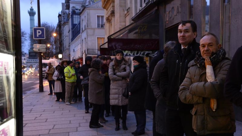 People wait outside a newsagents kiosk in Paris on Wednesday. Photograph: AFP/Getty/Bertrand Guaybertrand