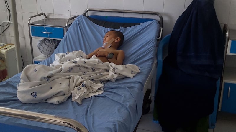 A burka-clad Afghan woman sits next to a child receiving treatment at a hospital after he got injured in a bomb blast in Kunduz. Photograph: AFP via Getty Images