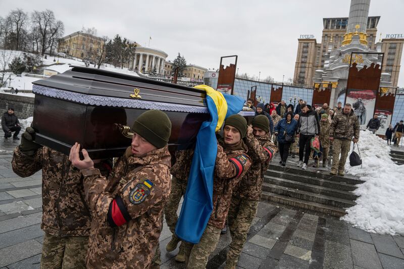Honour guards carry the coffin of Ukrainian serviceman Andrii Trachuk during his funeral service in Independence square in Kyiv (AP Photo/Evgeniy Maloletka)