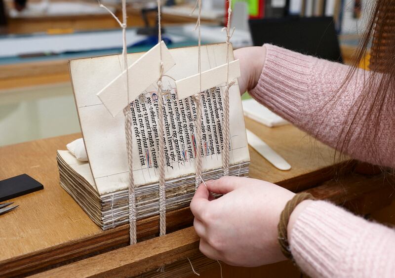 Sewing the binding of a manuscript, a method of conservation. Photograph: Trinity College Dublin