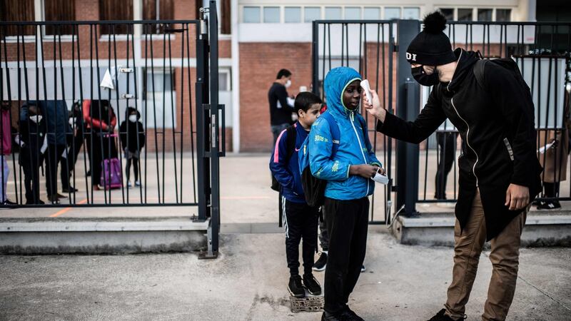 Pupils have their temperature checked before entering the entering the Saint-Exupery school in the Paris’ suburb of La Courneuve on May 14th as primary schools in France re-open this week after an almost two-month closure. Photograph: Martin Bureau/AFP via Getty