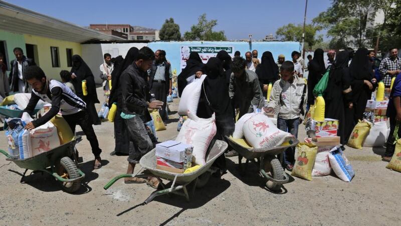 Yemenis load into wheel barrows their family food rations provided by a local relief group, in Sana’a, Yemen, on September 15th. Photograph:  EPA/YAHYA ARHAB