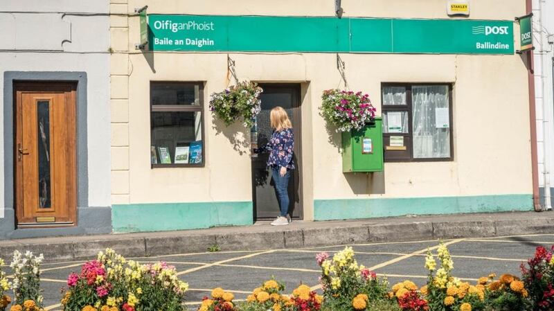 Postmistress Ann Moran closes the door of Ballindine post office at the end of  its last day of business. Photograph: Keith Heneghan