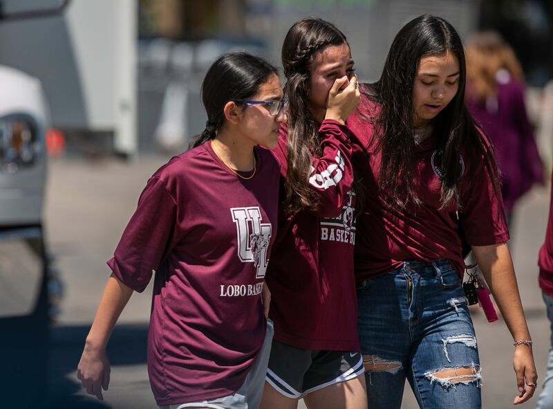 Overcome with emotion, young people comfort each other after leaving a memorial created outside Robb Elementary School in Uvalde, Texas, on Thursday (Josie Norris/The San Antonio Express-News via AP)