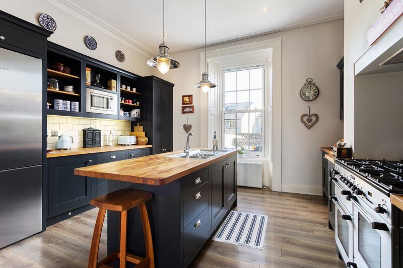 The kitchen has laminate wood flooring and a large central island with hardwood countertop. Photograph: Alex Urdaneta