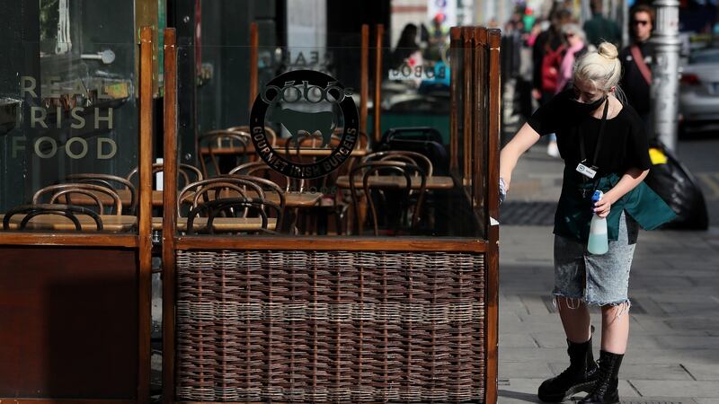 A worker cleans the outdoor dining area of a restaurant in Dublin’s city centre before the further restrictions were introduced last weekend. Photograph: Brian Lawless/PA Wire