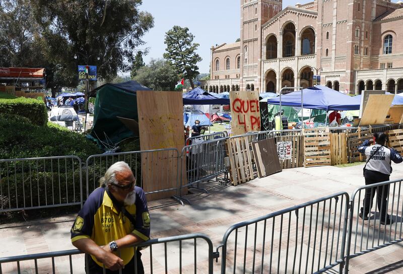 A private security guard stands outside the encampment of pro-Palestinian protesters on UCLA campus. Photograph: Caroline Brehman/EPA