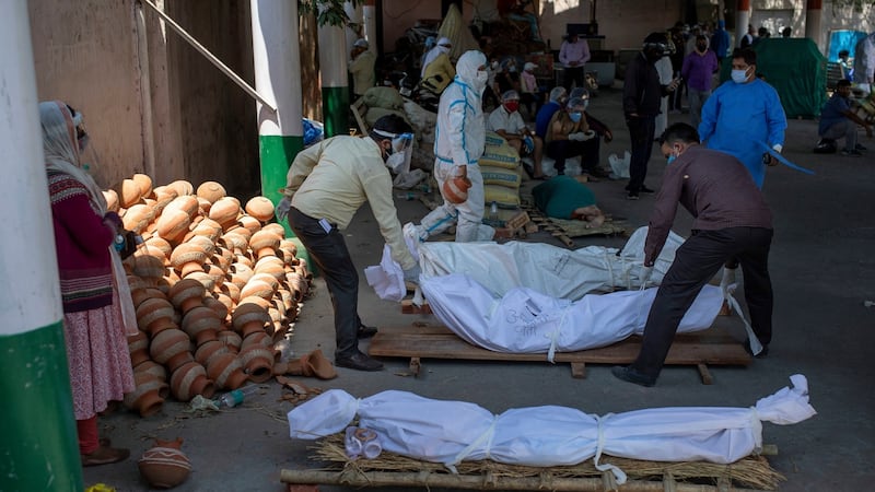 People line up bodies of those who died of Covid-19 at a crematorium in New Delhi. Photograph:  Altaf Qadri/AP