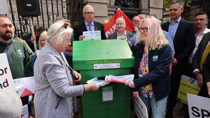 Catherine Clancy from the  Irish Senior Citizens Parliament and Beth O’Reilly from USI posting their bills at the Cost of Living Coalition’s protest outside the Dáil. Photograph: Dara Mac Donaill