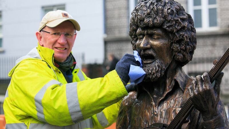 Sculptor John Coll  puts the finishing touches to his Luke Kelly statue on South King Street, to mark the 35th anniversary of the death of the musician. Photo: Gareth Chaney/Collins