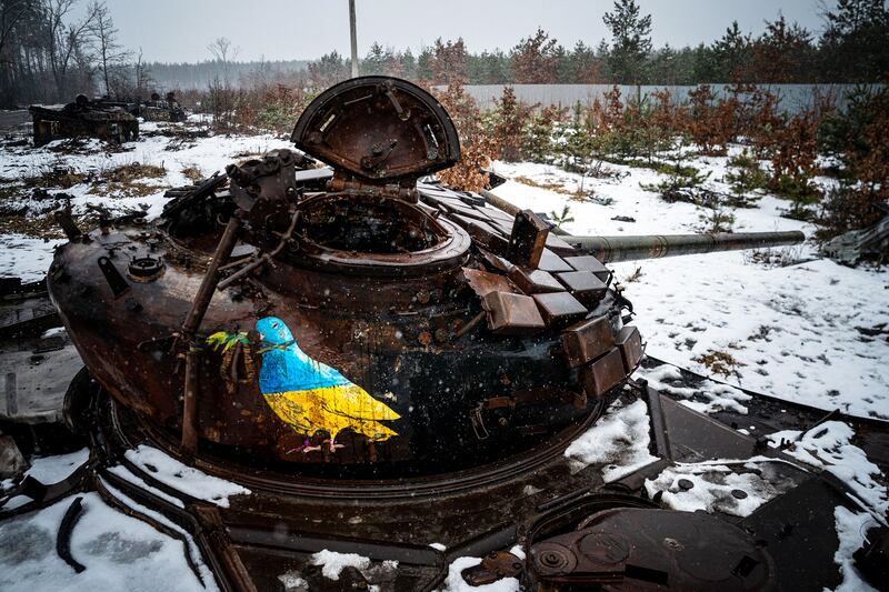 A street-art piece by Italian urban artist Tvboy on a destroyed Russian tank near the village of Dmytrivka, outside Kyiv. Photograph: Getty Images