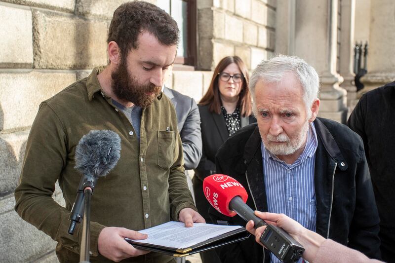 David Flannery, whose wife Elaine died in 2014, listens as his son, Eamonn reads a statement to media outside the Four Courts, Dublin. Photograph: Collins Courts