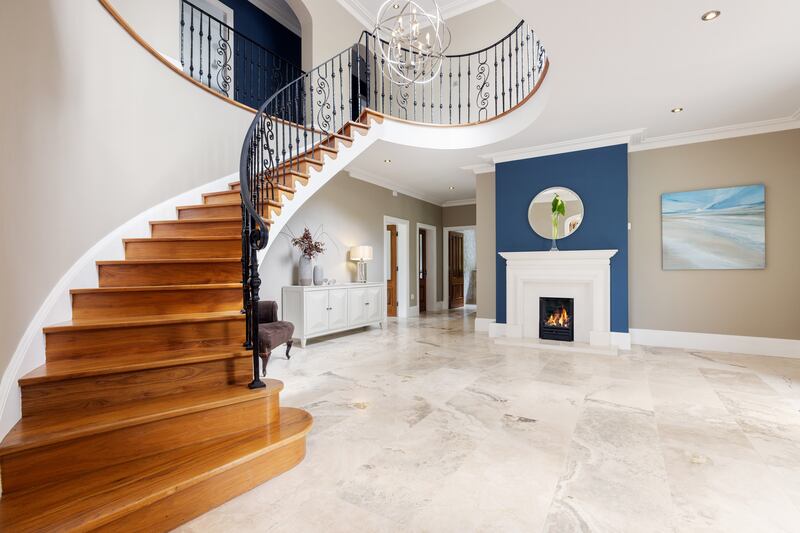 A sweeping staircase lies in the front hall