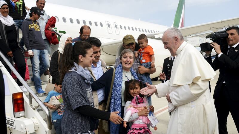 Pope Francis welcomes a group of Syrian refugees after landing at Ciampino airport in Rome following a visit at the Moria refugee camp in the Greek island of Lesbos on Saturday. Photograph:  Filippo Monteforte/Pool/Reuters