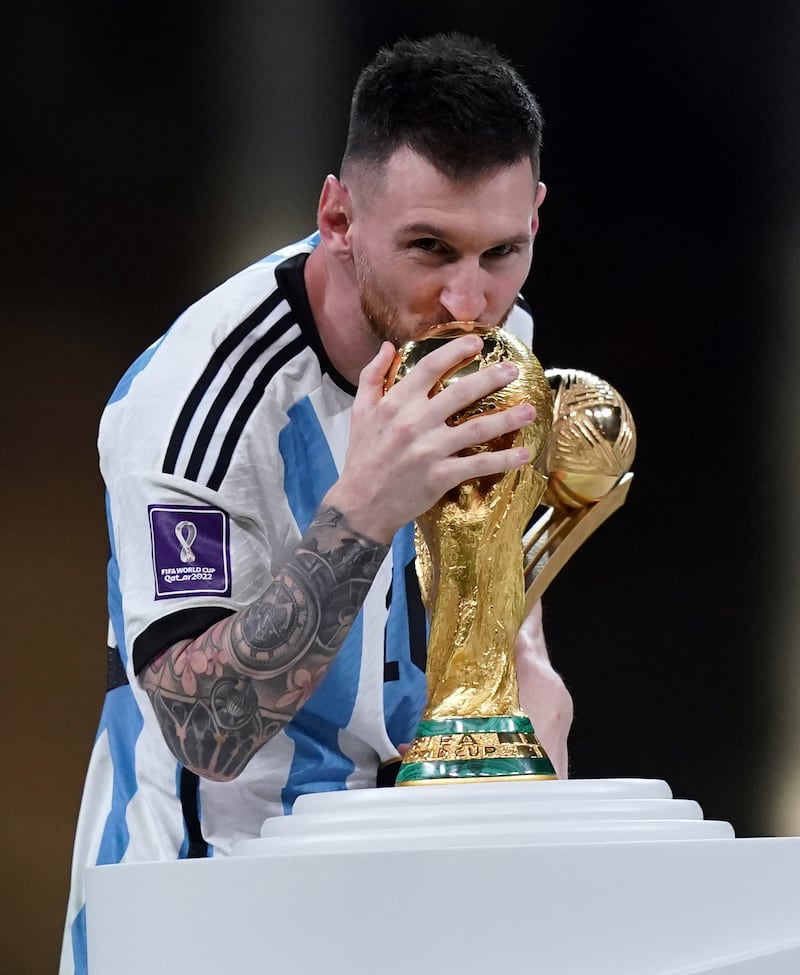Argentina's Lionel Messi kisses the FIFA World Cup trophy after being presented with the Golden Ball award following victory at the World Cup. It was Messi's fifth World Cup and he finally followed in the footsteps of his hero Diego Maradona, who won the trophy in 1986. Photograph: Mike Egerton/PA