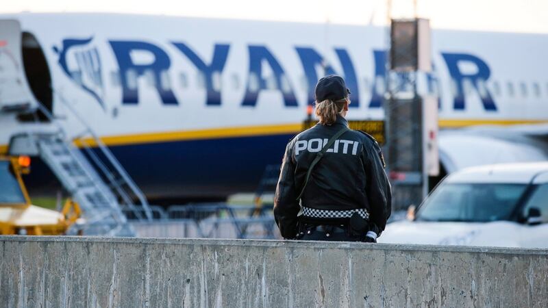 A police officer stands guard near a Ryanair plane on Rygge Airport in Moss, near Oslo, on Sunday  where a police bomb squad was deployed to check the plane. The plane was scheduled to fly to Manchester, England. Photograph: EPA