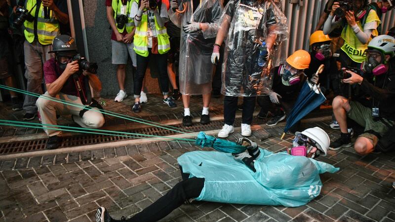 A protester fires a makeshift slingshot near the government headquarters in Hong Kong on Saturday. Photograph: Getty