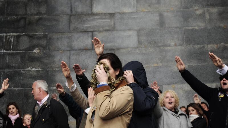 A woman covers her face as she and others perform a Fascist salute after attending a mass service outside the basilica where the tombs of Spain’s former dictator General Francisco Franco and Jose Antonio Primo de Rivera, founder of the right-wing group Falange, lie in the Valle de los Caidos (Valley of the Fallen) near Madrid in November, 2011. Photograph: Reuters/Susana Vera