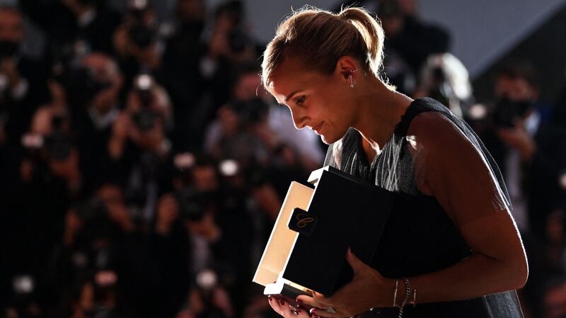 TOPSHOT - French director Julia Ducournau poses with her trophy during a photocall after she won the Palme d'Or for the film "Titane" during the closing ceremony of the 74th edition of the Cannes Film Festival in Cannes, southern France, on July 17, 2021. (Photo by CHRISTOPHE SIMON / AFP) (Photo by CHRISTOPHE SIMON/AFP via Getty Images)