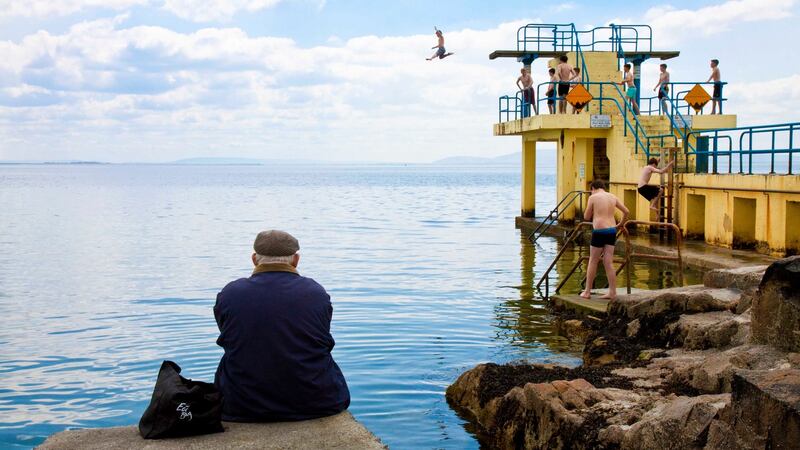 A man watches people jump off the diving platform at Blackrock, Salthill, Co. Galway. Photograph: Andy Newman