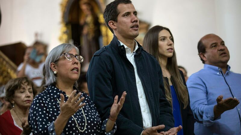 Opposition national assembly president Juan Guaido, who declared himself interim president of Venezuela, prays next to his wife Fabiana Rosales, second from right, during Mass at a church in Caracas, Venezuela. Photograph: Rodrigo Abd/AP Photo