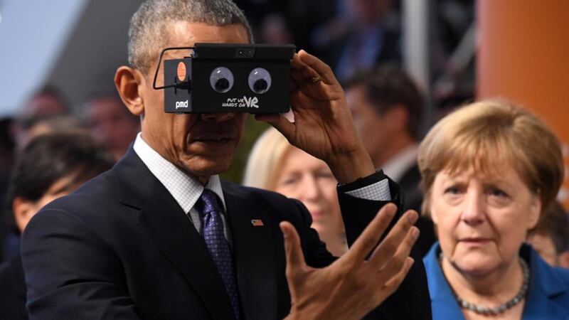 Reality check: President Obama tries a virtual-reality headset on a visit to a trade fair in Hannover with Angela Merkel. Photograph: Alexander Koerner/Getty