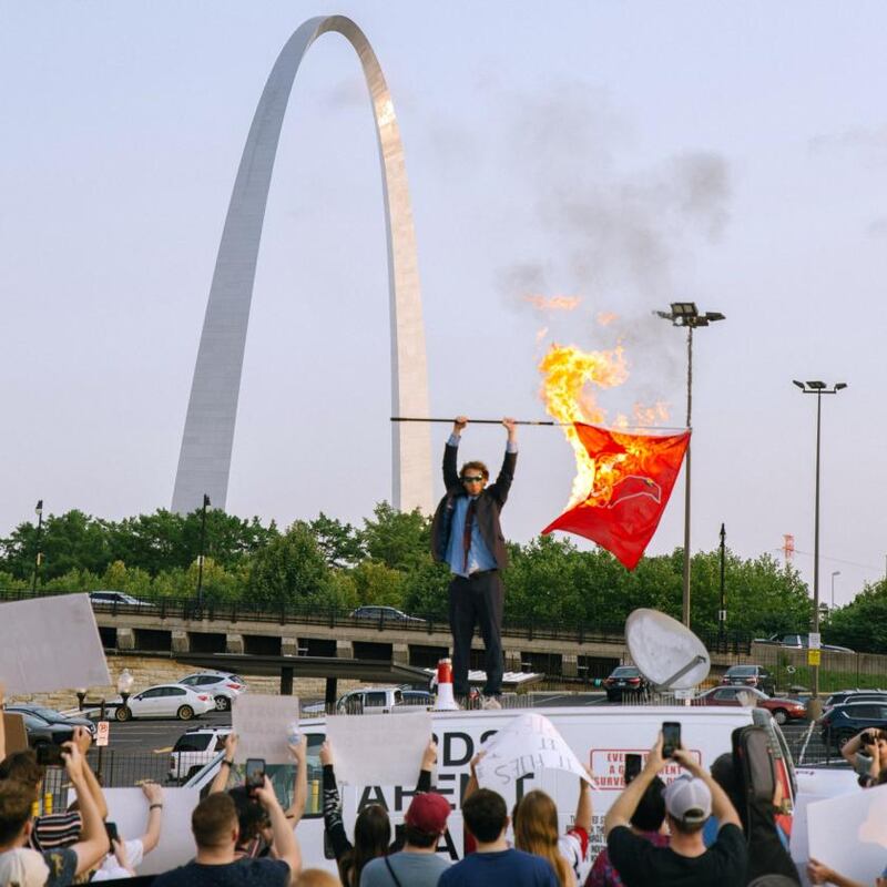 Peter McIndoe burns  a Cardinals flag in St Louis, Missouri, during a satirical protest of the baseball team’s  logo,  in July. Photograph: Madeline Houston/The New York Times