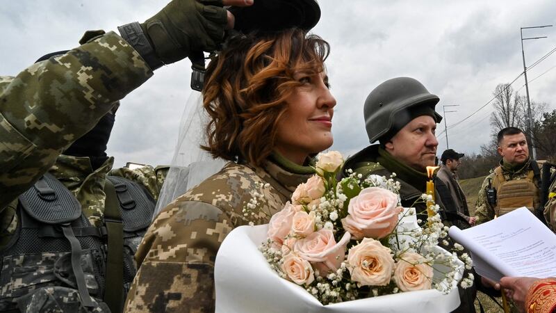Members  of the Ukrainian territorial defence, Lesya (centre) and Valery, get married near a  checkpoint on the outskirts of Kyiv  on Sunday, March 6th. Photograph: Genya Savilov/AFP/Getty