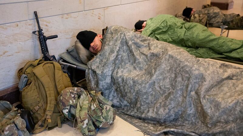 Members of the National Guard rest in the Capitol Visitor Center on Capitol Hill in Washington, on Friday after hundreds of troops were allowed to return there to rest after being forced by Capitol police to rest in a parking garage on Thursday. Photograph: Michael Reynolds/EPA