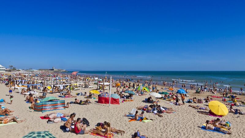 Lazy days: People sunbathing at the beach in Carcavelos town, near Lisbon. Photograph: iStock/Getty Images
