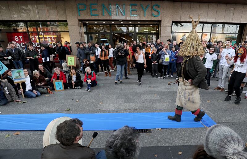 REBELLION NOW THE FASHION? Protesters dressed as wren boys perform an impromptu "fashion show" outside Penneys on O'Connell Street in Dublin during an Extinction Rebellion (XR) demonstration. Fashion retailers have come under intense scrutiny in the last year from environmental activists. Photograph: Brian Lawless/PA Wire