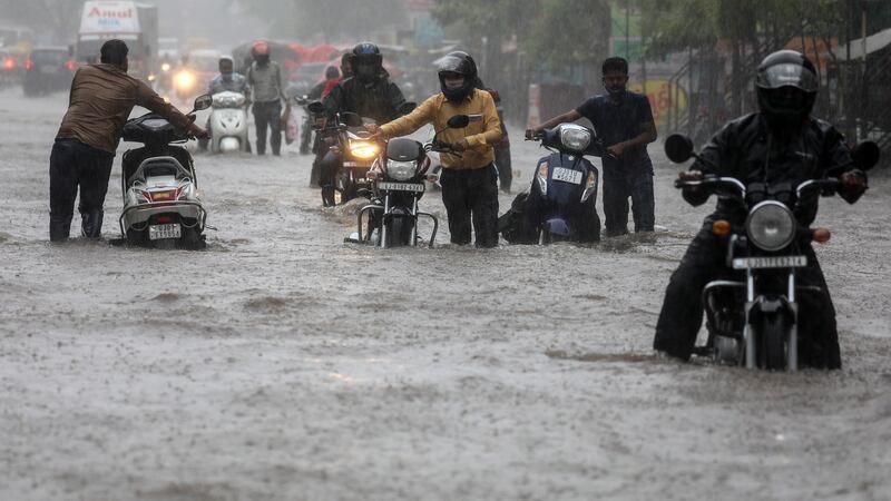 People wade through a flooded street in Ahmedabad, Gujarat, during heavy rainfall after Cyclone Tauktae. Photograph: Divyakant Solanki/EPA