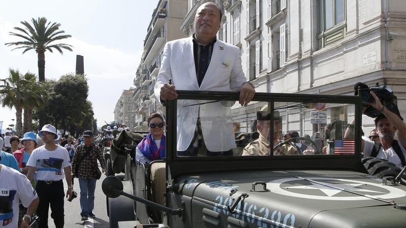 Chinese businessman and CEO of the group “Tiens” Li Jinyuan (C) parades  in Nice as part of the celebration. Photograph: Valery Hache/AFP/Getty Images