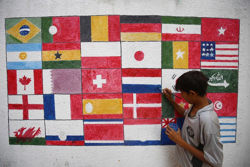 An artist in Karachi, Pakistan paints flags of participating nations on a wall ahead of the World Cup Qatar 2022. The event will take place from November 20th to December 18th. 
