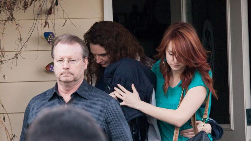 An unidentified person whose head is covered by clothing leaves the home of the parents of Amanda Knox, surrounded by others including her father, Curt Knox (left), yesterday in Seattle, Washington. Ms Knox and former boyfriend Raffaele Sollecito were found guilty today in Italy of the November 2007 murder of Meredith Kercher in a retrial. Photograph: Getty
