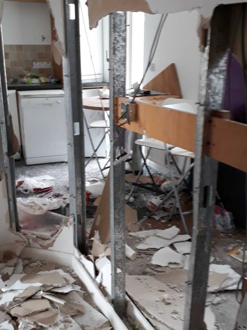 The damaged walls and kitchen area of the apartment.