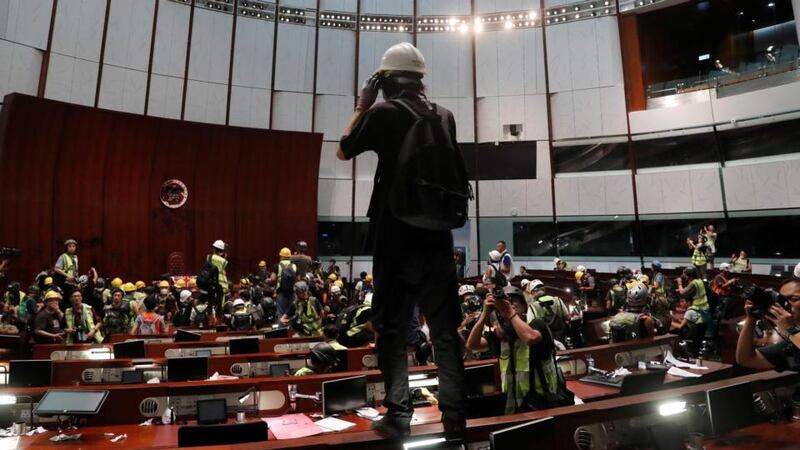 A protester stands on a desk inside a chamber after they broke into the legislative council building during the anniversary of Hong Kong’s handover to China in Hong Kong on Monday. Photograph:  Reuters/Tyrone Siu