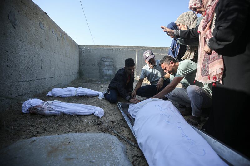Mourners preparing for the burial of members of the Al-Satra family during their funeral in Khan Younis, south Gaza. Photograph: Yousef Masoud/The New York Times
                      