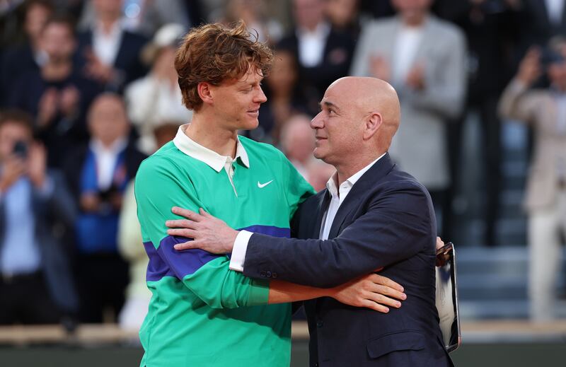 Jannik Sinner receives his runner-up trophy ceremony from Andre Agassi. Photograph: Clive Brunskill/Getty Images
