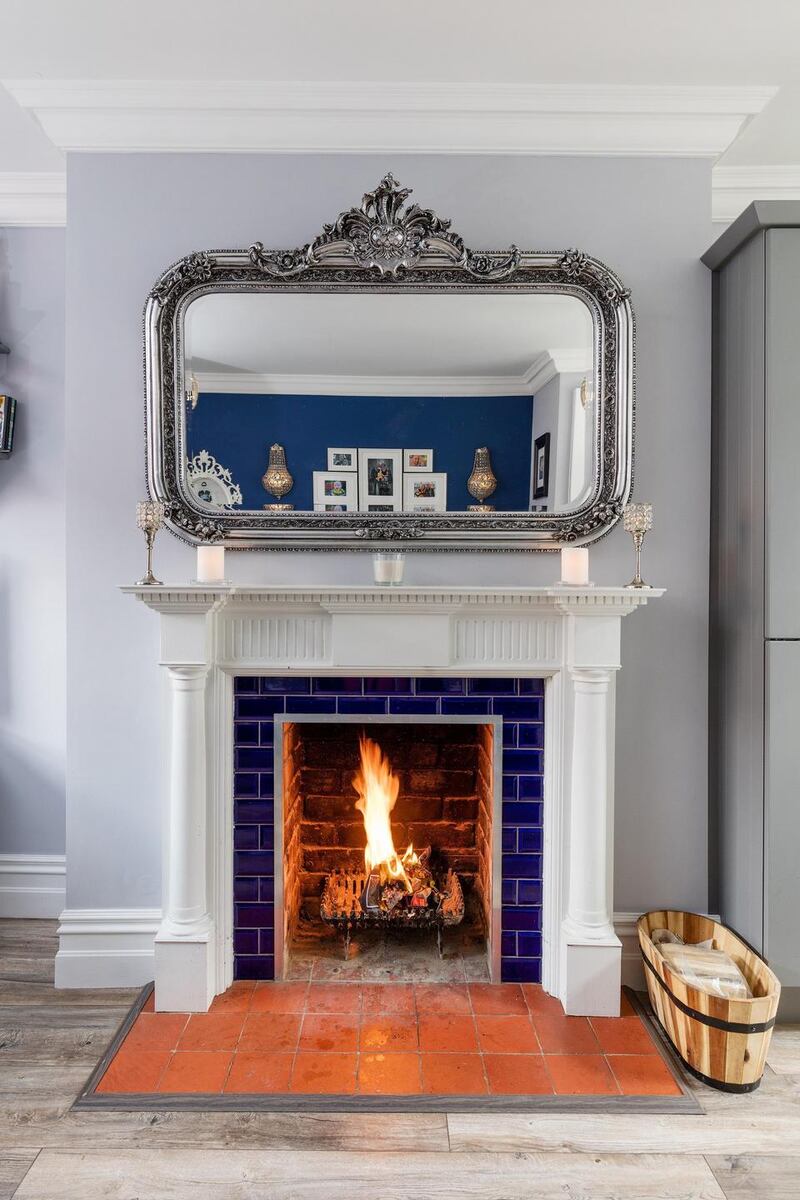 A large fireplace with reclaimed tile inset adds cachet