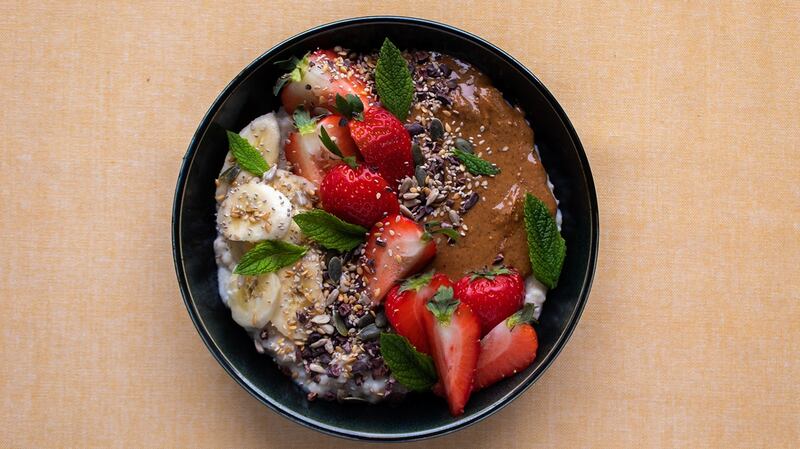 Porridge topped with fruit and seeds.