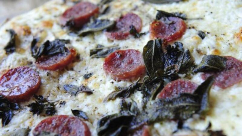 Pizza with creme fraiche and salami.