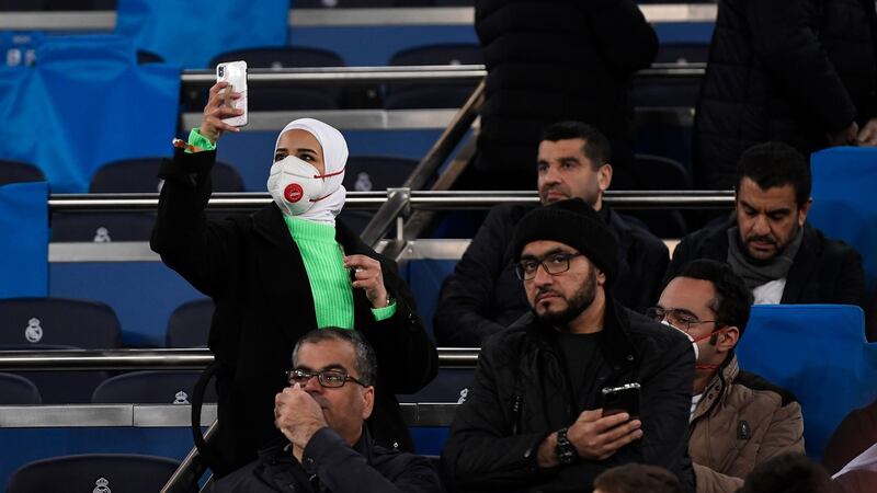 A fan wearing a protective mask against the coronavirus takes a picture before the Uefa Champions League  first-leg football match between Real Madrid  and Manchester City at the Santiago Bernabeu stadium in Madrid, Spain, on Wednesday.  Photograph: Pierre-Philippe Marcou/AFP/Getty