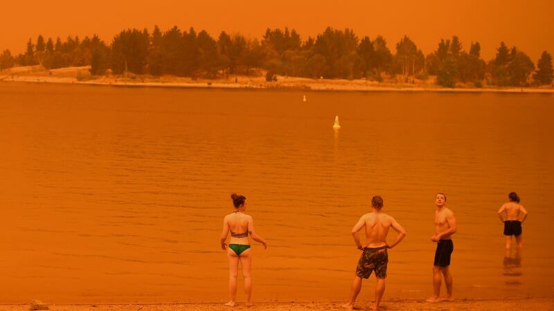 Residents take a dip to cool down at Lake Jindabyne, under a red sky due to smoke from bushfires, in the town of Jindabyne in New South Wales on Saturday. Photograph: Saeed Khan/AFP/Getty Images)