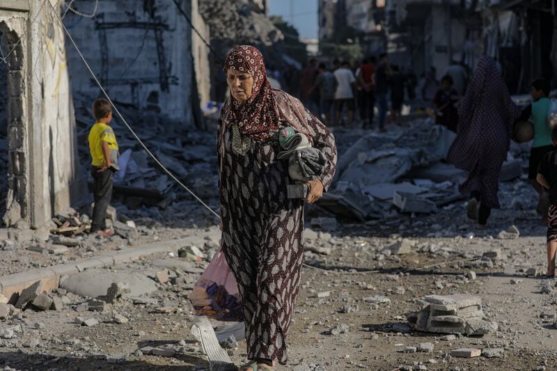 A Palestinian woman passes destroyed buildings following an Israeli air strike in Gaza City on Tuesday. Photograph: Mohammed Saber/EPA